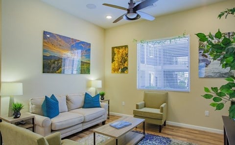 a living room with furniture and a ceiling fan